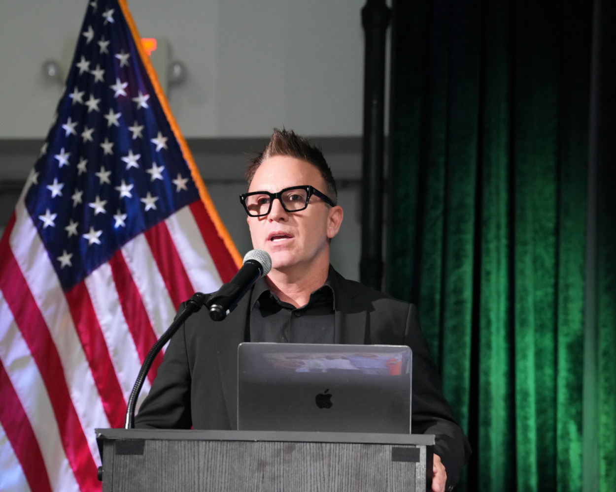 A keynote at the CommHIT25 podium